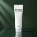 Mousse Nettoyante Dive-In Acide Hyaluronique - visuel produit sur fond vert premium