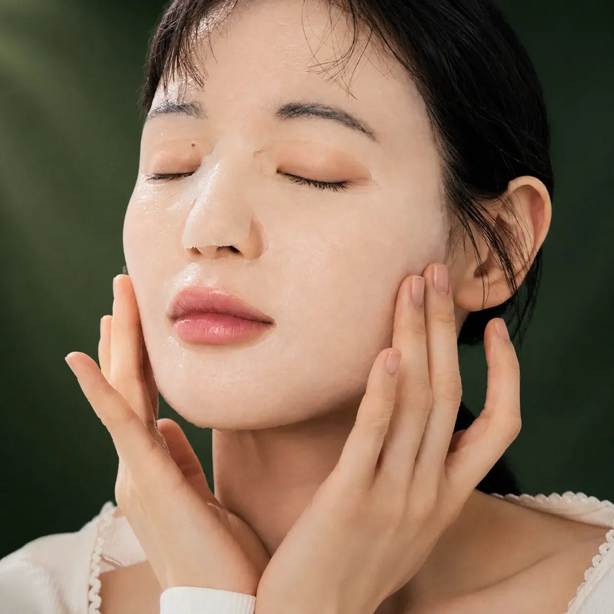 Femme portant un masque tissu translucide sur le visage, sur fond vert