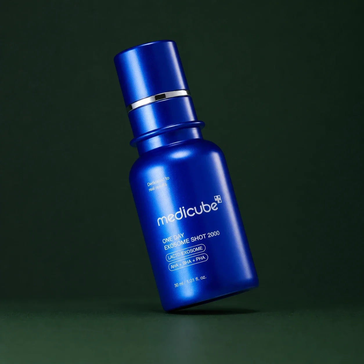 Medicube Ampoule Exosome Shot Pores 2000, flacon bleu incliné sur fond vert profond