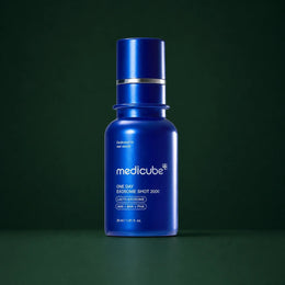 Medicube Ampoule Exosome Shot Pores 2000, flacon bleu sur fond vert profond