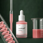 Medicube Ampoule PDRN Rose et Peptides avec verrerie de laboratoire sur fond vert profond