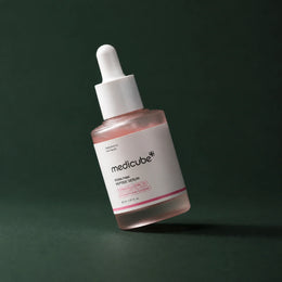 Medicube Ampoule PDRN Rose et Peptides, flacon incliné sur fond vert profond