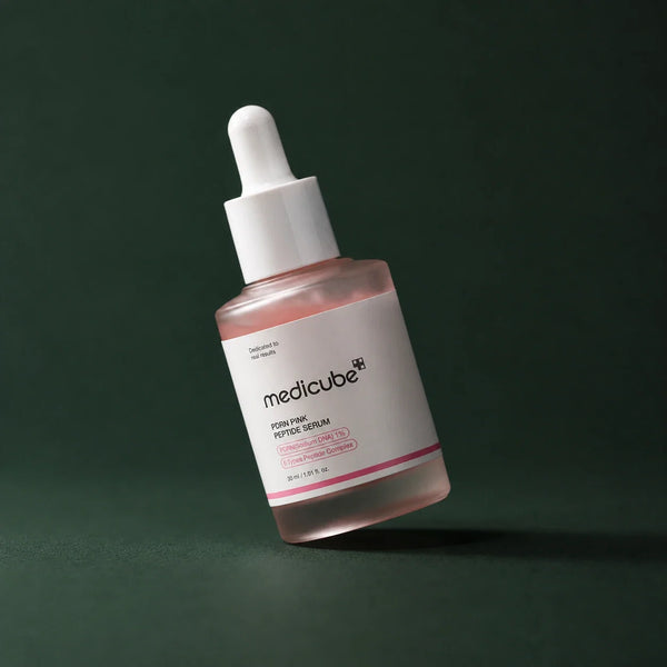 Medicube Ampoule PDRN Rose et Peptides, flacon incliné sur fond vert profond