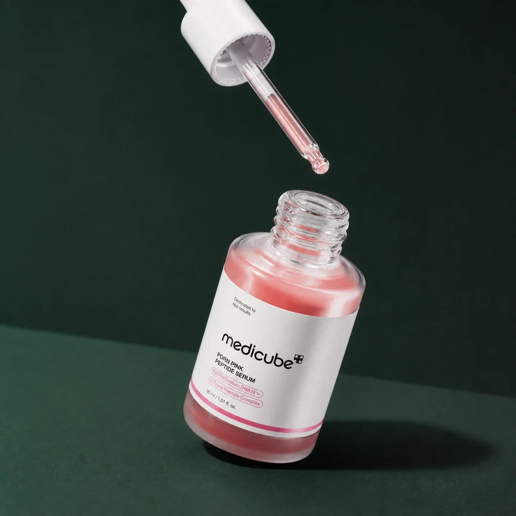 Medicube Ampoule PDRN Rose et Peptides avec pipette sur fond vert profond