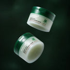 Deux pots de Baume Démaquillant Super Cica Medicube sur fond vert profond