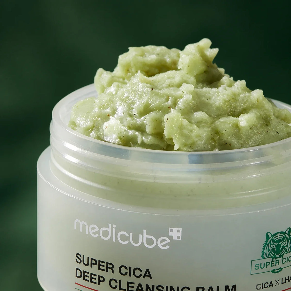 Texture du Baume Démaquillant Super Cica Medicube sur fond vert profond