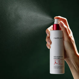 Application de la Brume Corps Red Clear Cica Medicube sur fond vert profond