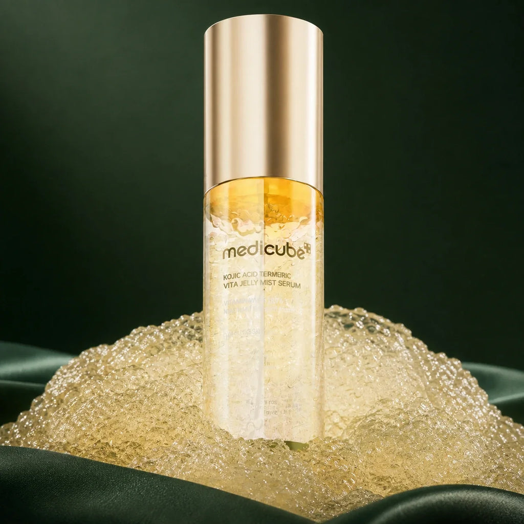Brume-Sérum Kojic Acid Turmeric Vitamin Gold Medicube dans sa gelée dorée sur fond vert profond