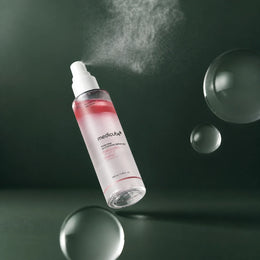 Medicube Brume Sérum PDRN Rose et Glutathion vaporisée sur fond vert profond