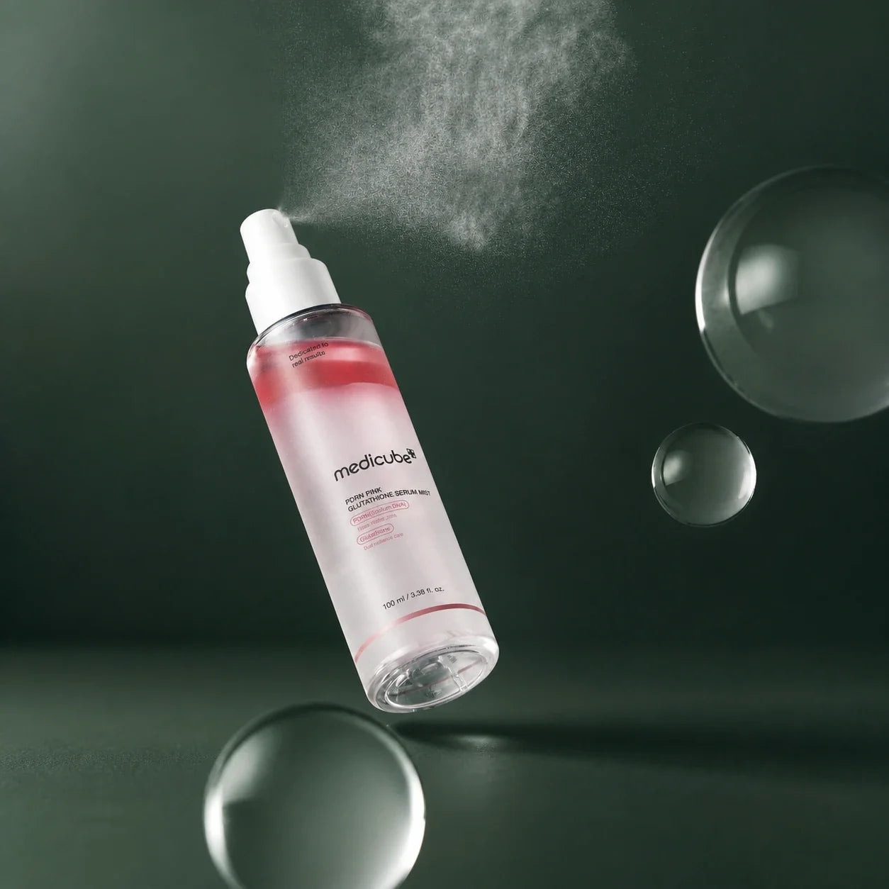 Medicube Brume Sérum PDRN Rose et Glutathion vaporisée sur fond vert profond