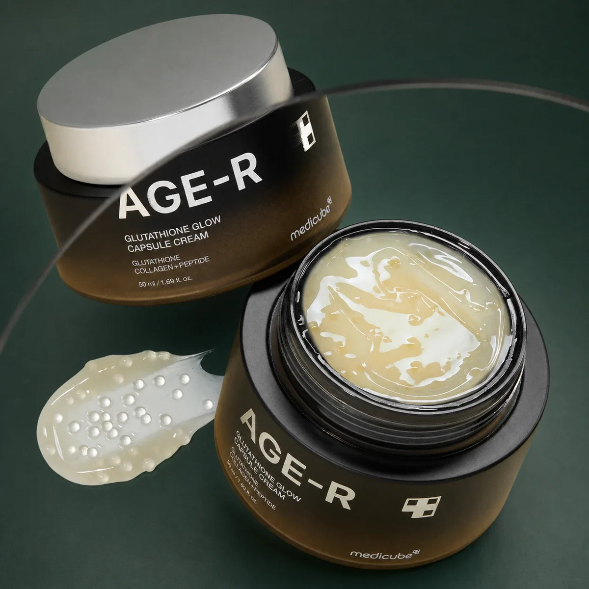 Medicube Crème Capsule Glutathion Glow AGE-R – deux pots et texture sur fond vert premium