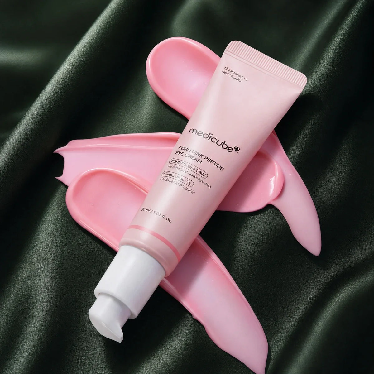 Crème Contour des Yeux PDRN Rose Peptides Medicube avec texture rose sur fond vert profond