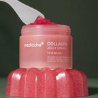 Medicube Crème Gelée au Collagène – pot ouvert et spatule sur fond vert premium