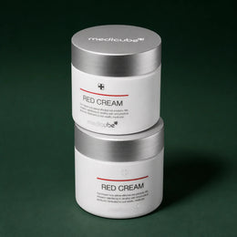 Deux pots de Crème Red 2.0 Plus Medicube sur fond vert profond