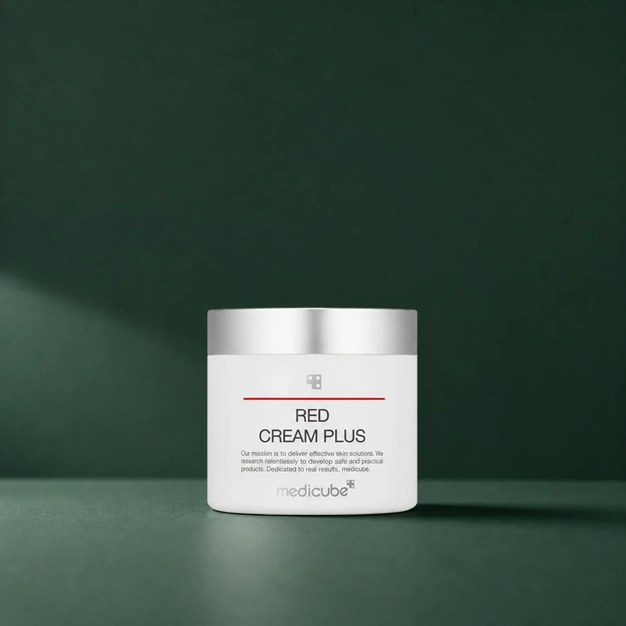 Crème Red 2.0 Plus Medicube en pot fermé sur fond vert profond