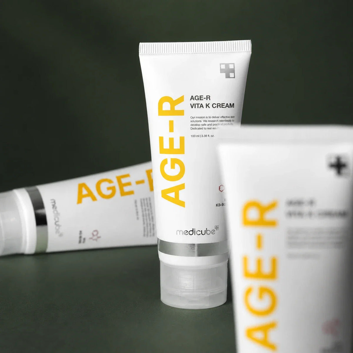 Medicube Crème Visage & Corps Vita K – composition de tubes sur fond vert premium
