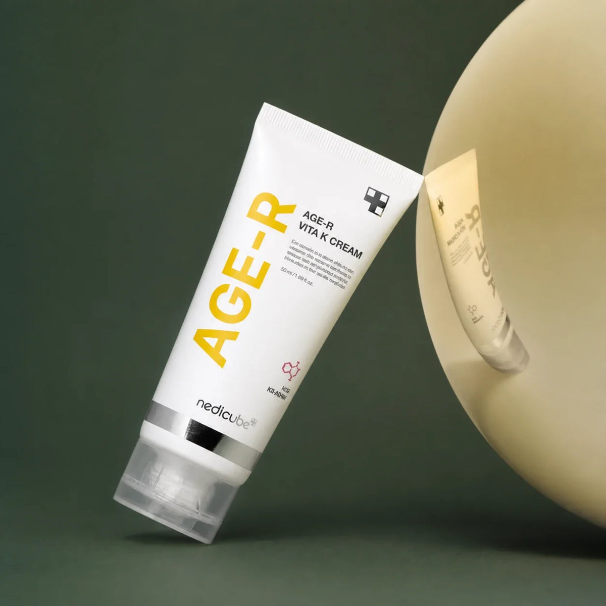 Medicube Crème Visage & Corps Vita K Grand Format – tube et miroir sur fond vert premium