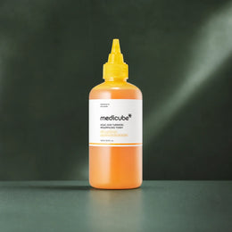 Lotion Medicube Kojic Acid Turmeric Resurfacing sur fond vert