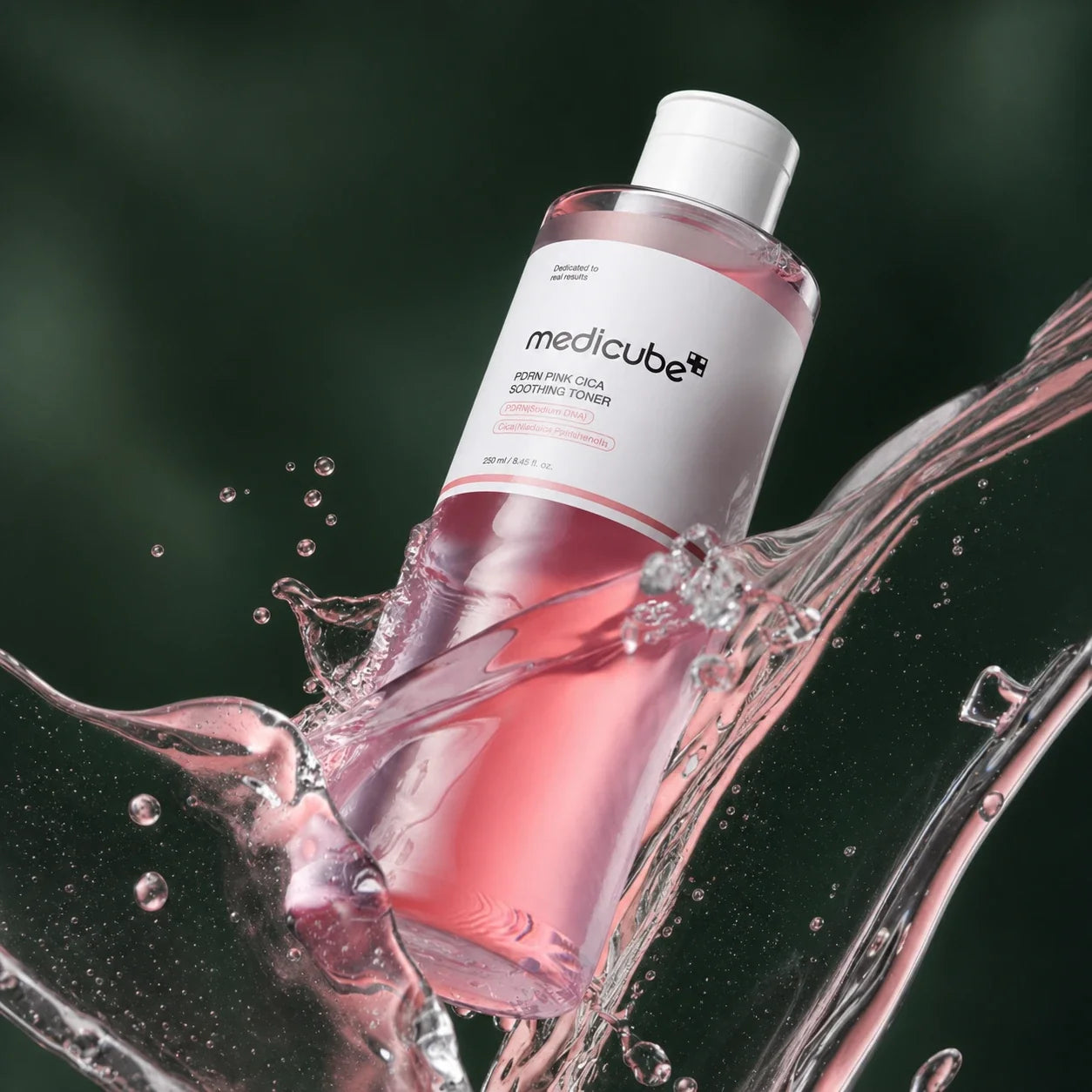 Medicube Lotion Tonique Apaisante PDRN Rose Cica avec éclaboussure sur fond vert profond