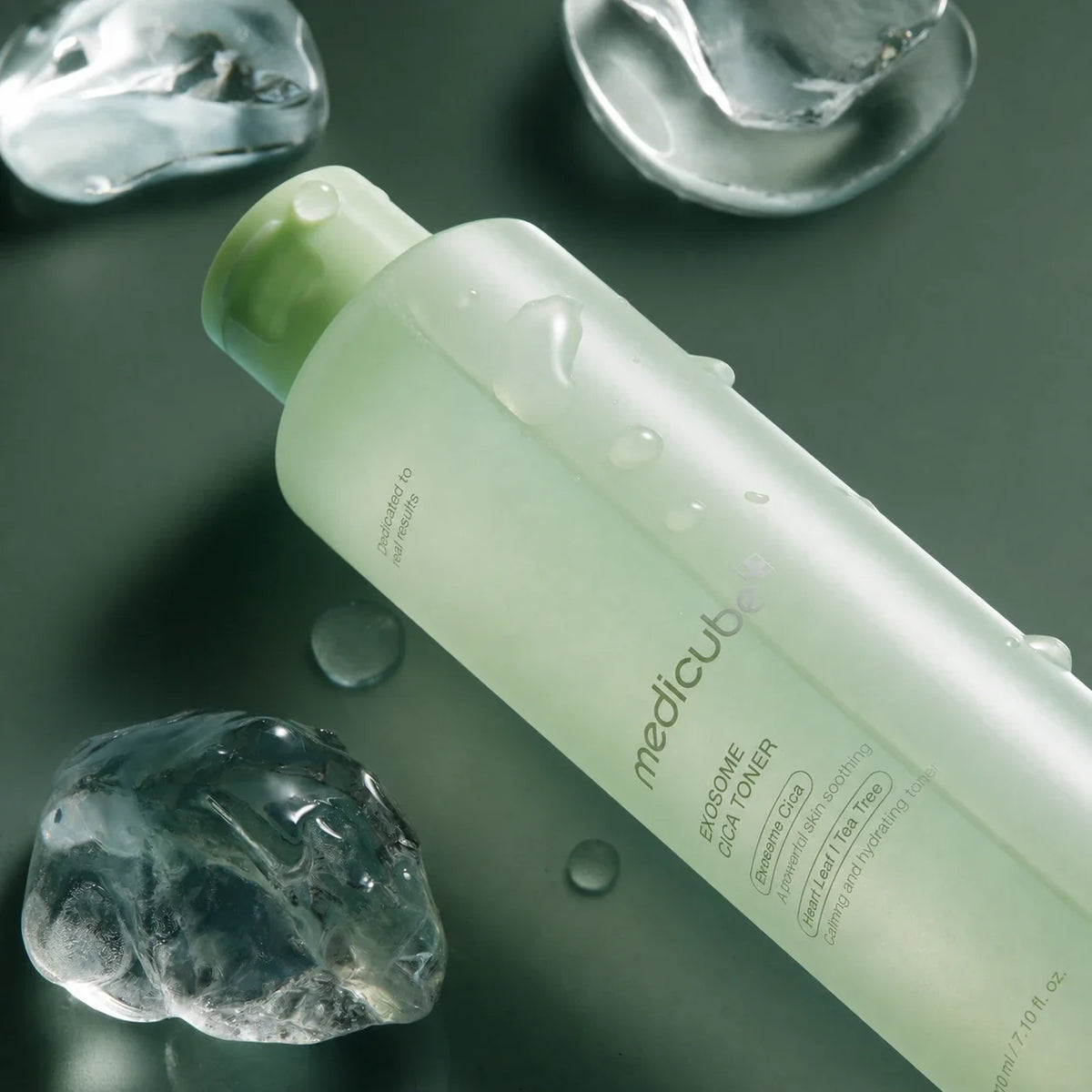 Medicube Lotion Tonique Exosome Cica avec glaçons sur fond vert profond