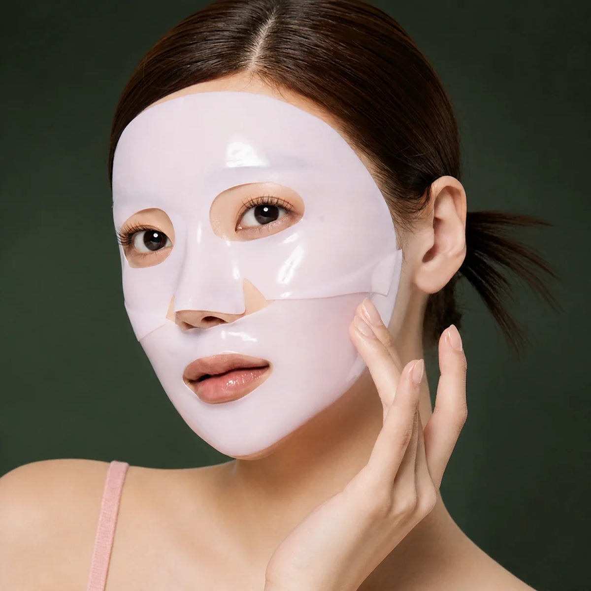 Medicube Masques Gel Collagène Rose PDRN – masque porté sur le visage sur fond vert premium