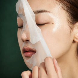Masque tissu Super Cica Medicube retiré du visage sur fond vert profond