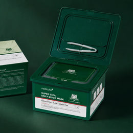 Boîte ouverte de Masques Quotidiens Super Cica Medicube avec pince sur fond vert profond