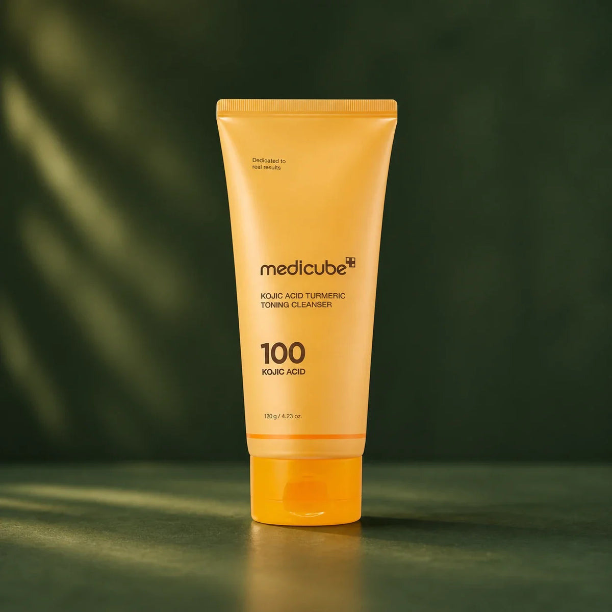 Nettoyant Medicube Kojic Acid Turmeric sur fond vert profond