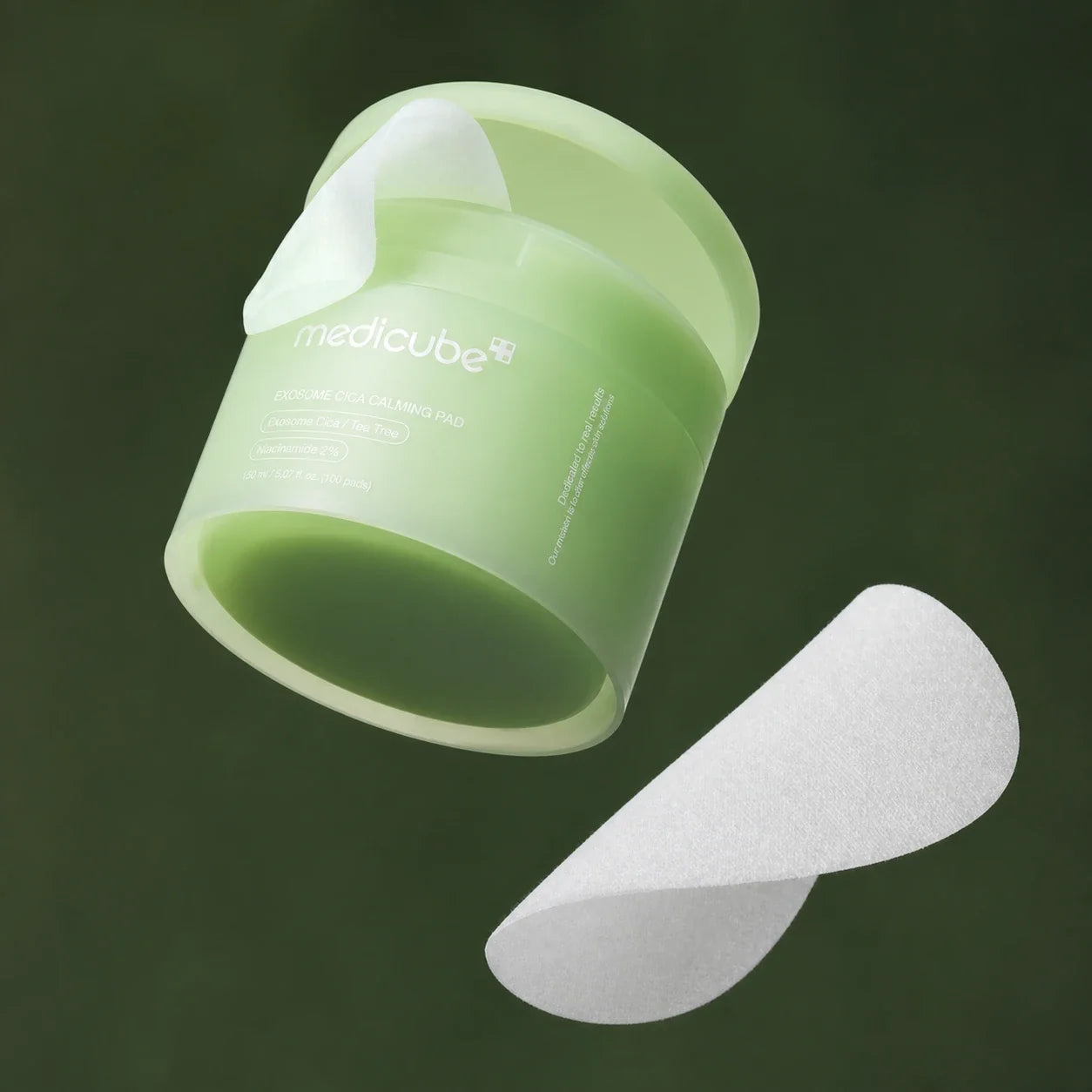 Medicube Pads Apaisants Exosome Cica, pot et disques sur fond vert profond