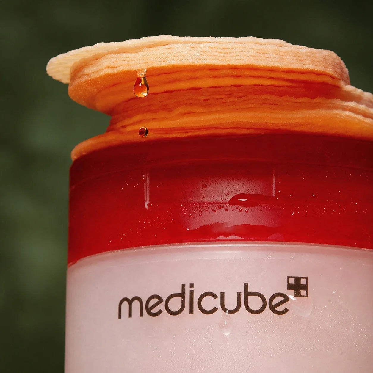 Gros plan des Pads Exfoliants Red Acide Succinique Medicube et gouttes de sérum
