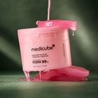 Pads Medicube PDRN Rose Collagène avec sérum sur fond vert profond