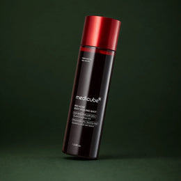 Medicube Peeling Corps Red Acne, flacon incliné sur fond vert profond
