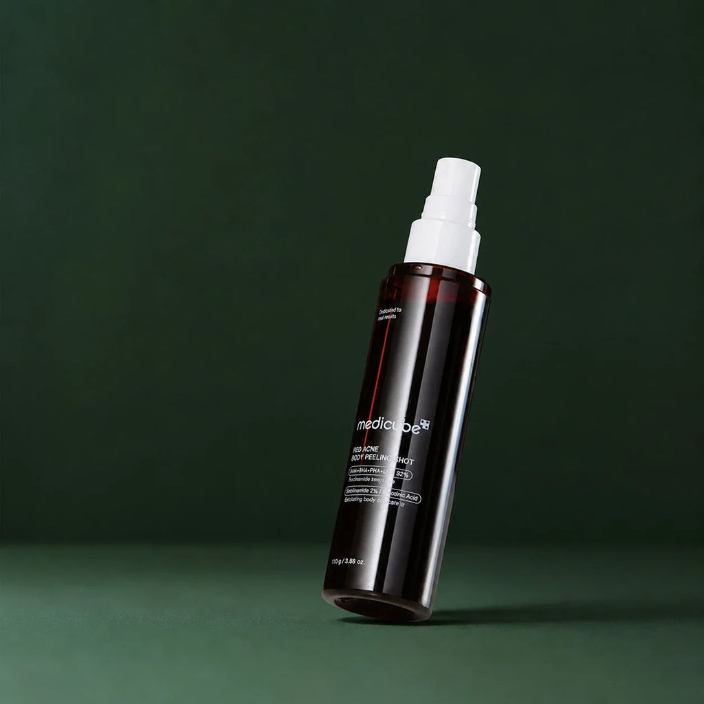 Medicube Peeling Corps Red Acne, flacon-pompe ouvert sur fond vert profond