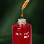 Peeling Visage Red Acne Medicube avec pipette et goutte sur fond vert profond