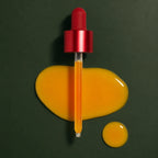 Pipette et texture du Peeling Visage Red Acne Medicube sur fond vert profond