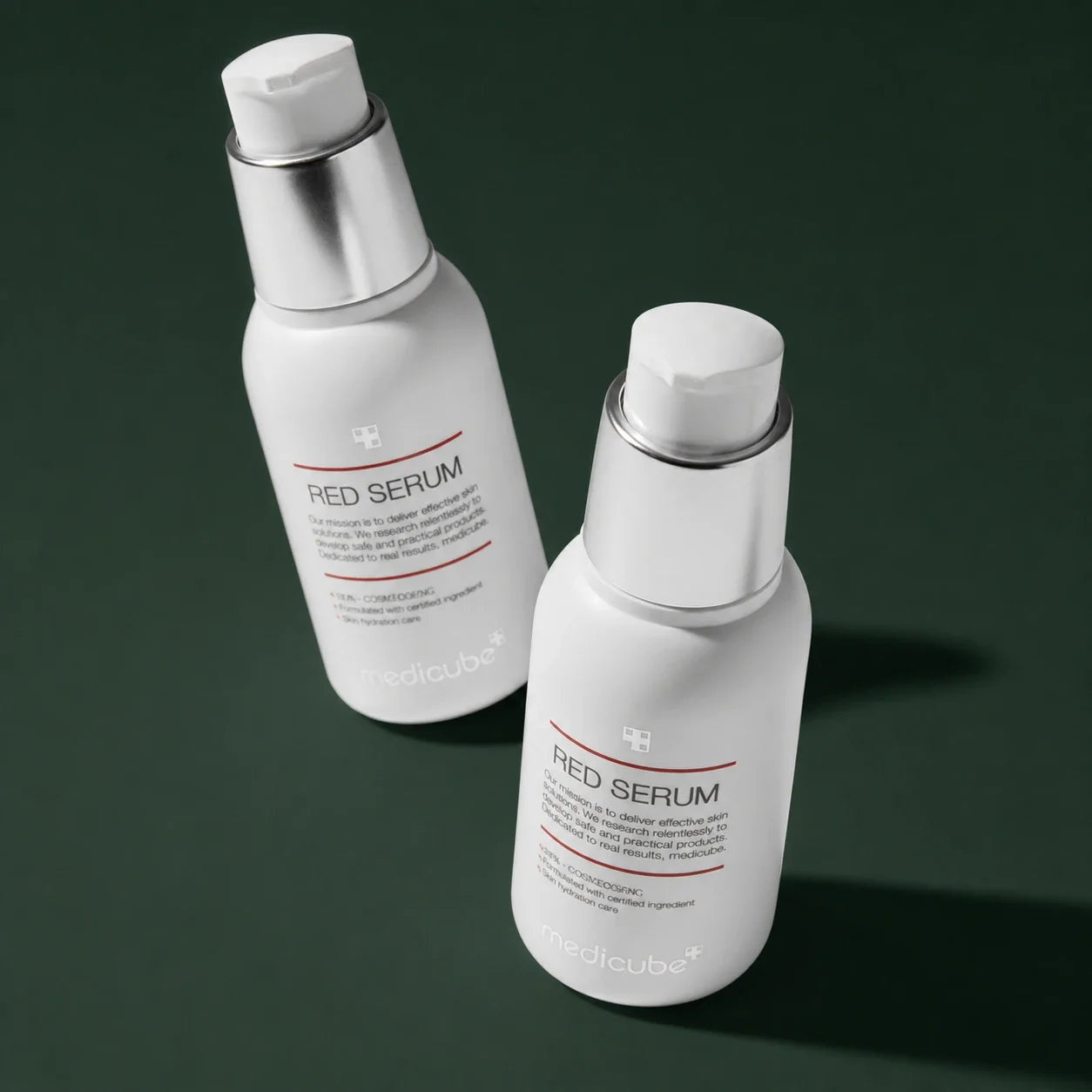 Medicube Sérum Apaisant Red, deux flacons-pompes sur fond vert profond