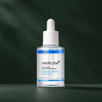 Sérum Medicube hyaluronique multi-peptides sur fond vert profond