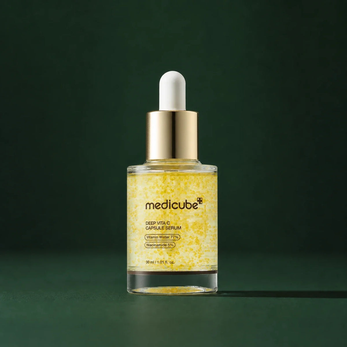 Sérum Medicube Deep Vita C Capsule sur fond vert profond