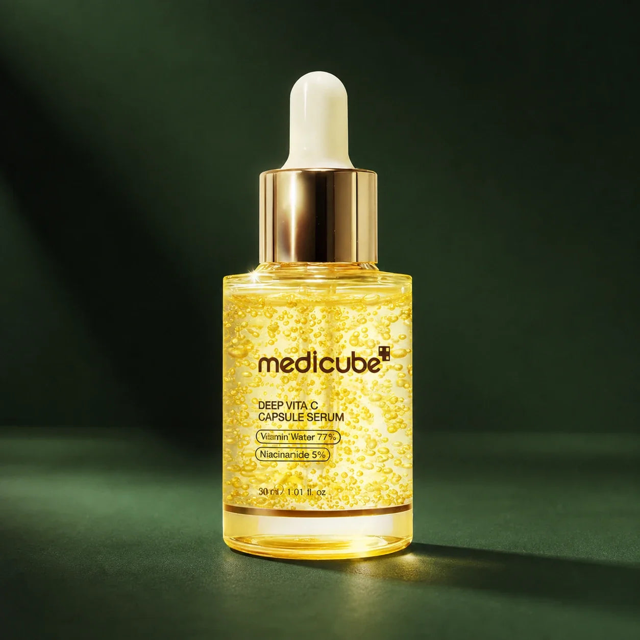 Flacon du sérum Medicube aux capsules de vitamine C en studio vert