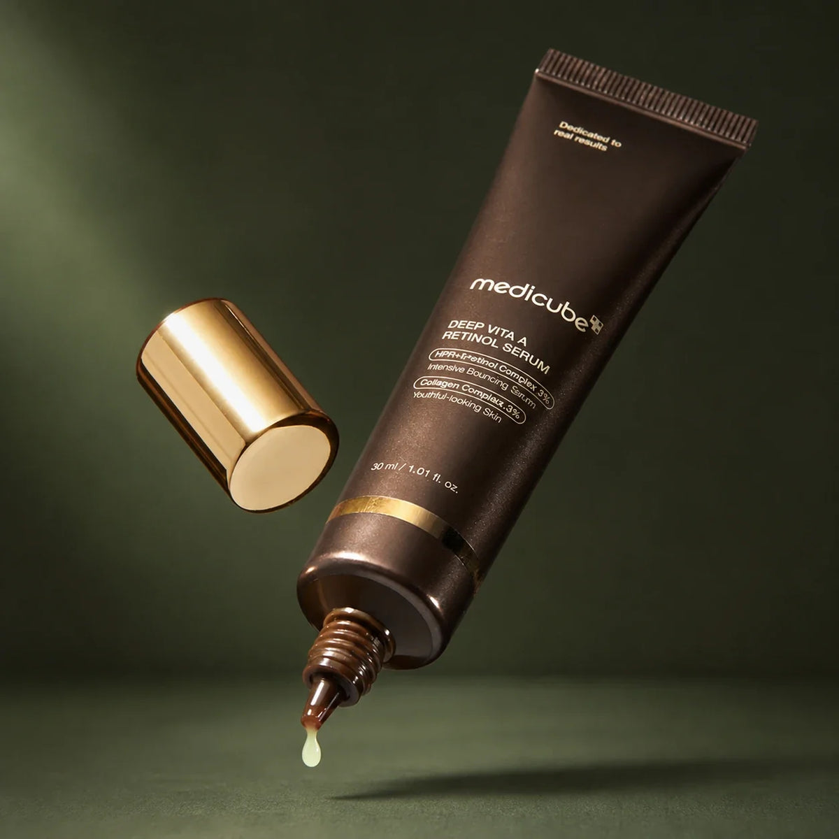 Tube Medicube Deep Vita A Retinol Serum ouvert sur fond vert