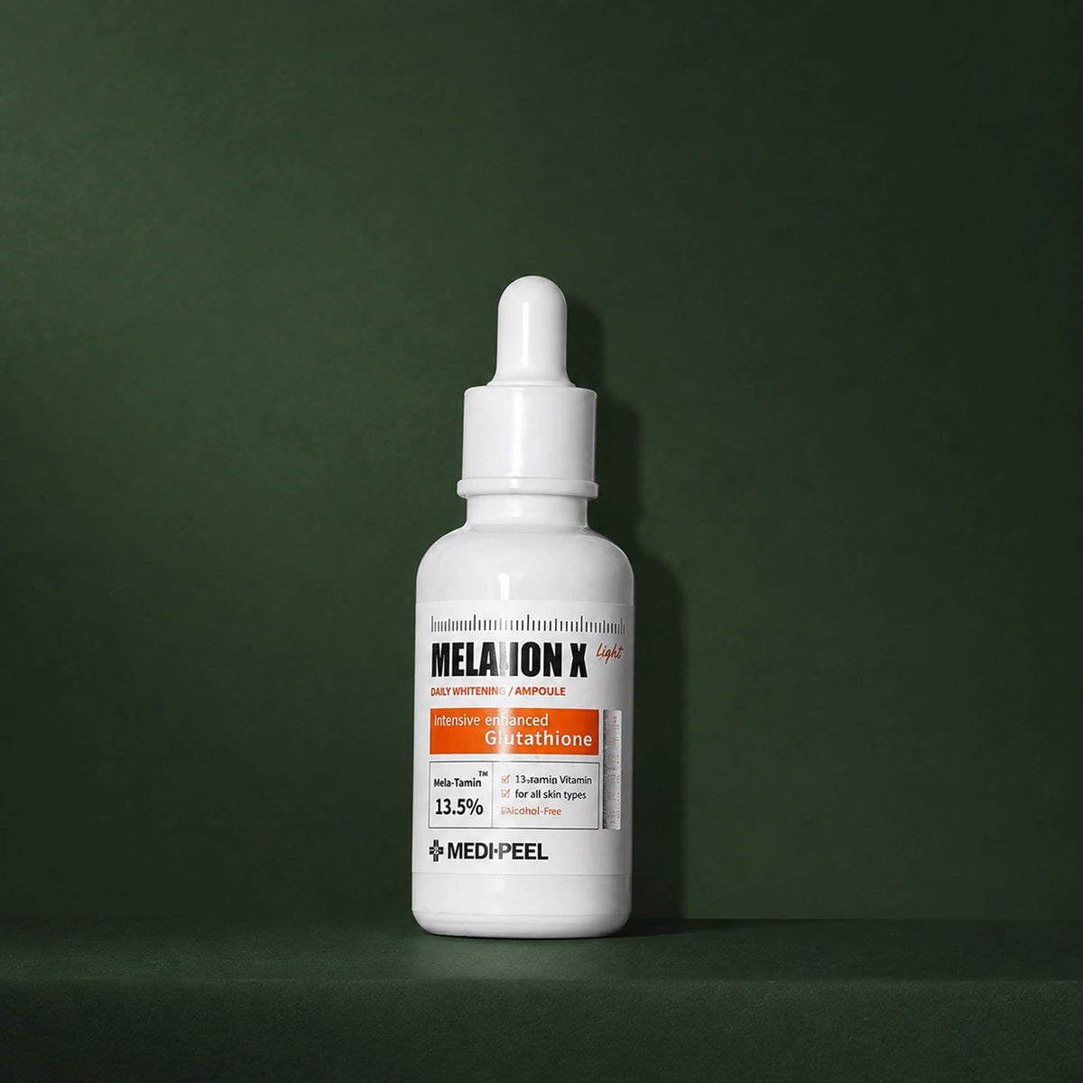Ampoule Éclat Légère Melanon X MEDIPEEL – vue principale sur fond vert profond.