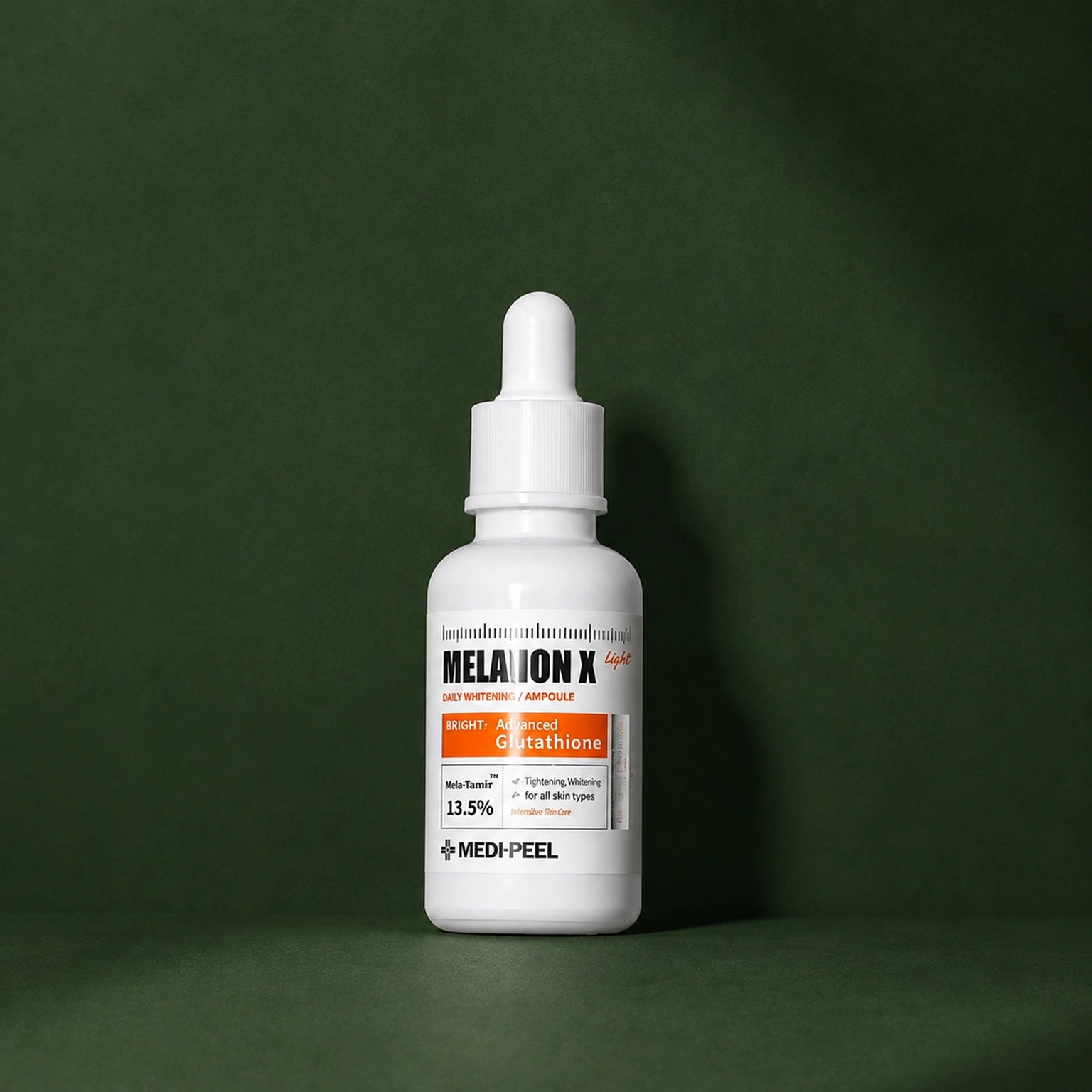 Ampoule Éclat Légère Melanon X MEDIPEEL – vue 2 sur fond vert profond.