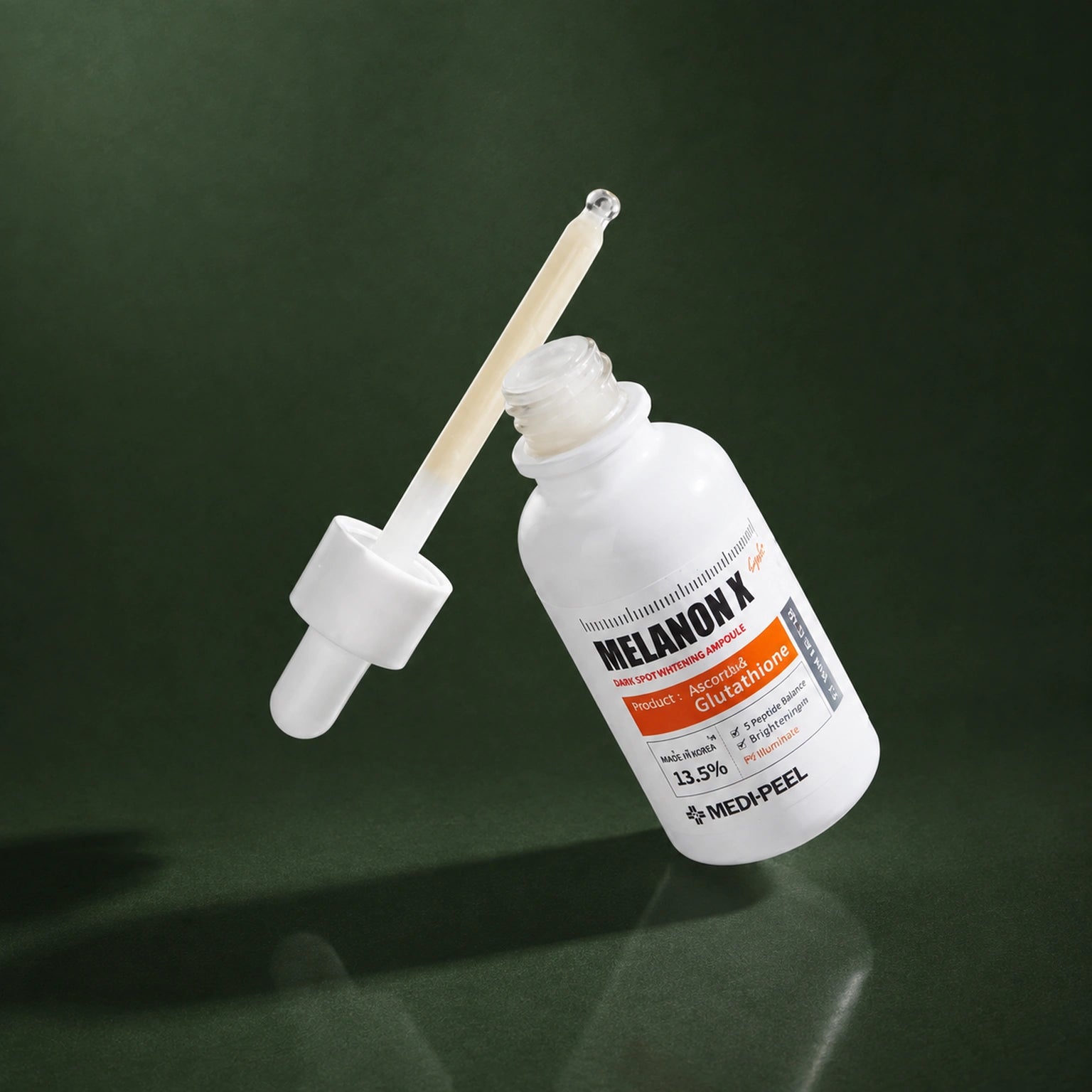 Ampoule Éclat Légère Melanon X MEDIPEEL – vue 3 sur fond vert profond.