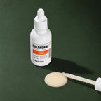 Ampoule Éclat Légère Melanon X MEDIPEEL – vue 4 sur fond vert profond.