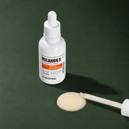 Ampoule Éclat Légère Melanon X MEDIPEEL – vue 4 sur fond vert profond.