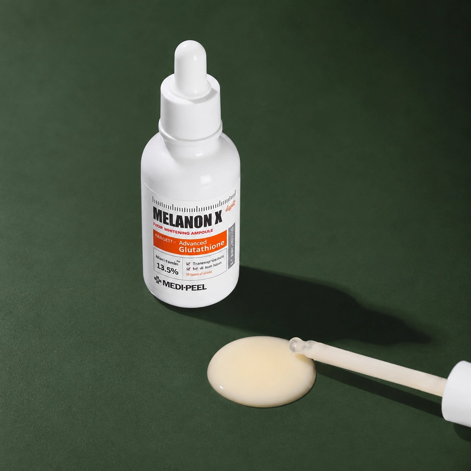 Ampoule Éclat Légère Melanon X MEDIPEEL – vue 4 sur fond vert profond.