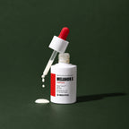 Ampoule Éclat Melanon X MEDIPEEL – vue 3 sur fond vert profond.