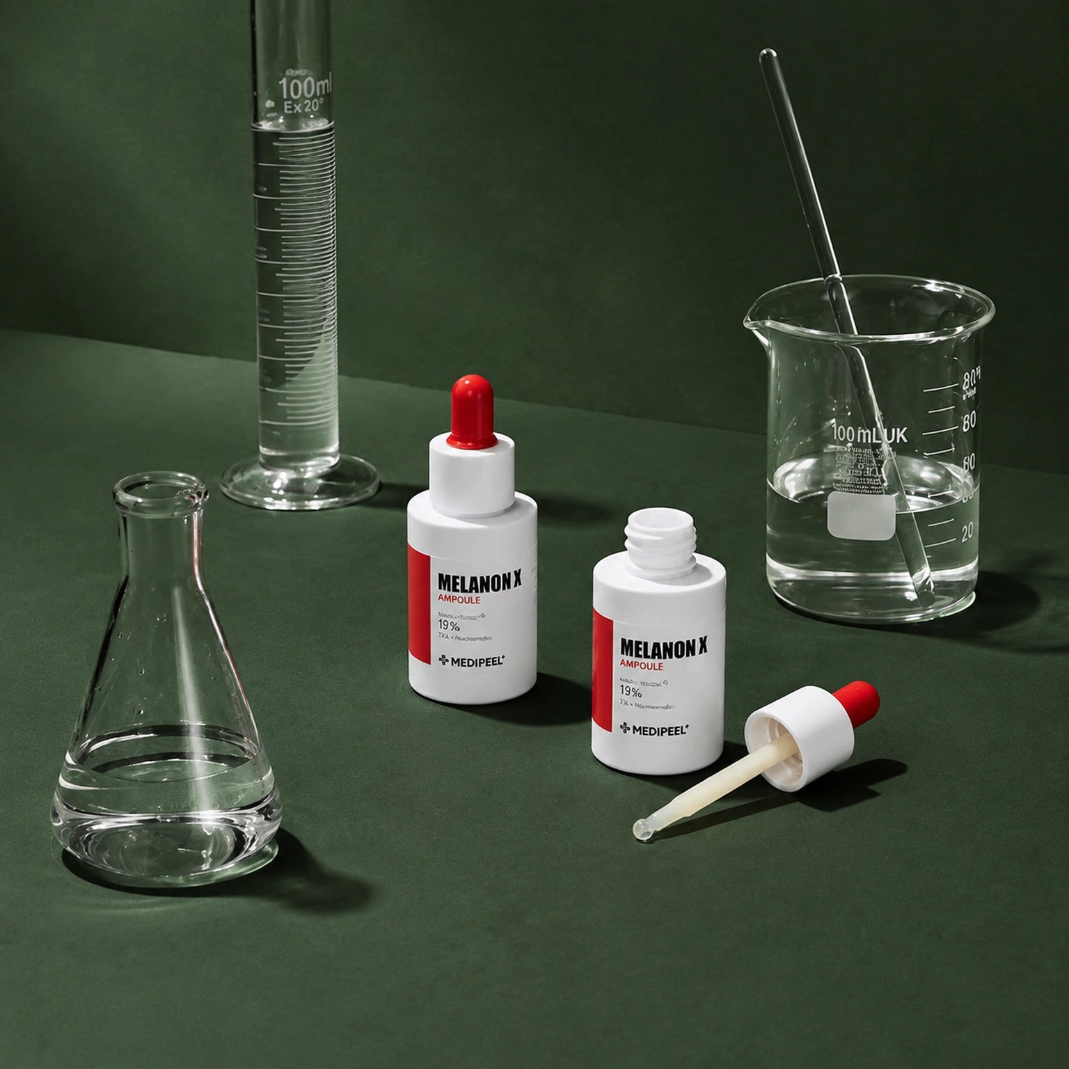 Ampoule Éclat Melanon X MEDIPEEL – vue 4 sur fond vert profond.