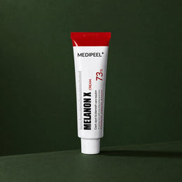 Crème Éclat Melanon X MEDIPEEL – vue 2 sur fond vert profond.