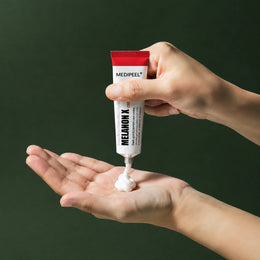 Crème Éclat Melanon X MEDIPEEL – vue 4 sur fond vert profond.
